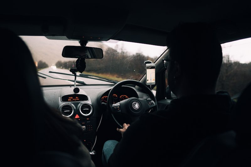 View of a car's steering wheel and the road ahead on a British street